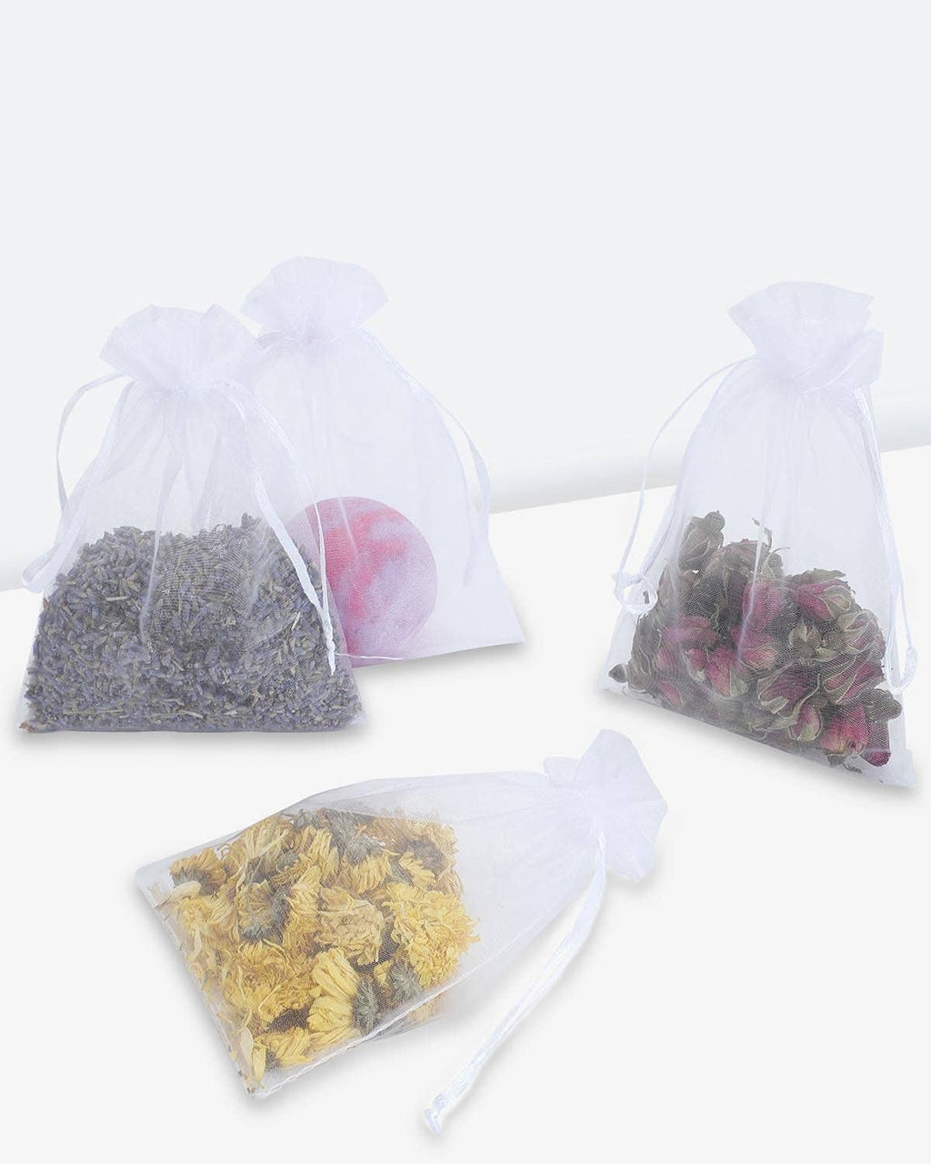 White mesh drawstring bags with draw cords, filled with assorted candies