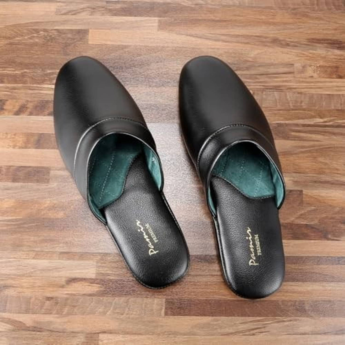Black leather scuff slippers with teal lining, slip-on style shown on wooden floor