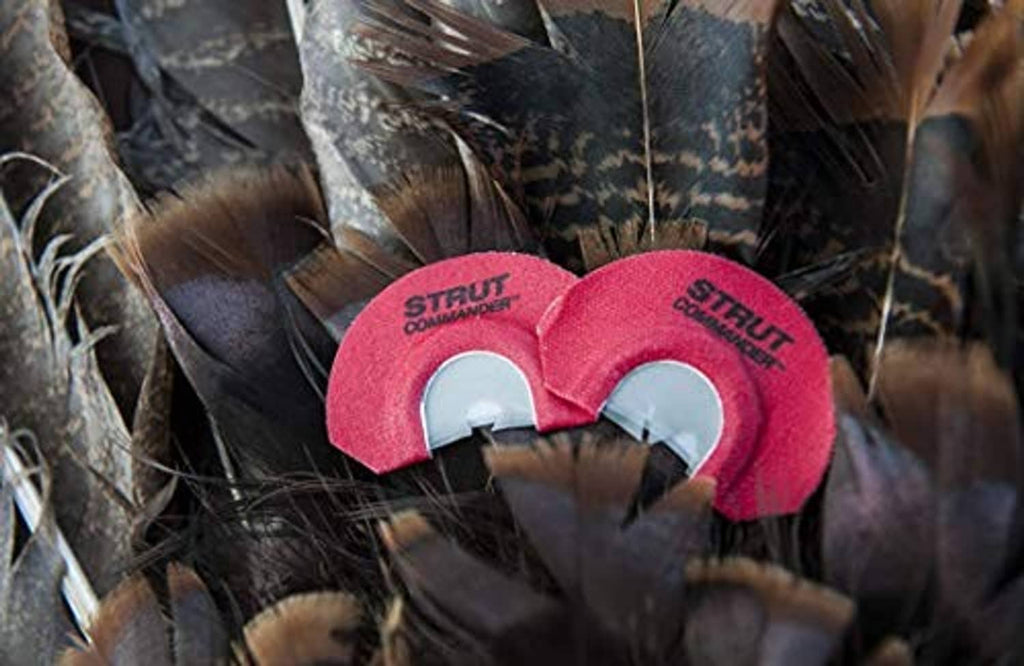 Pair of red foam turkey mouth calls nestled among turkey feathers