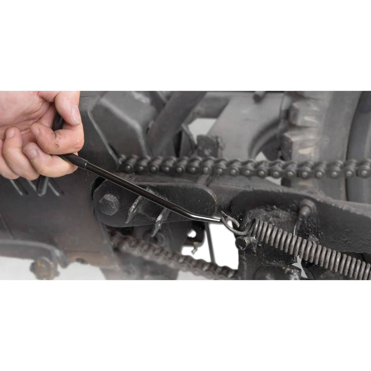 Spring hook tool being used to release headlight adjusting spring