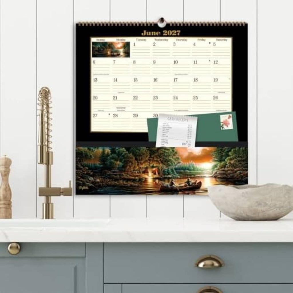 Wall-hanging June 2027 pocket calendar with scenic river art above dresser