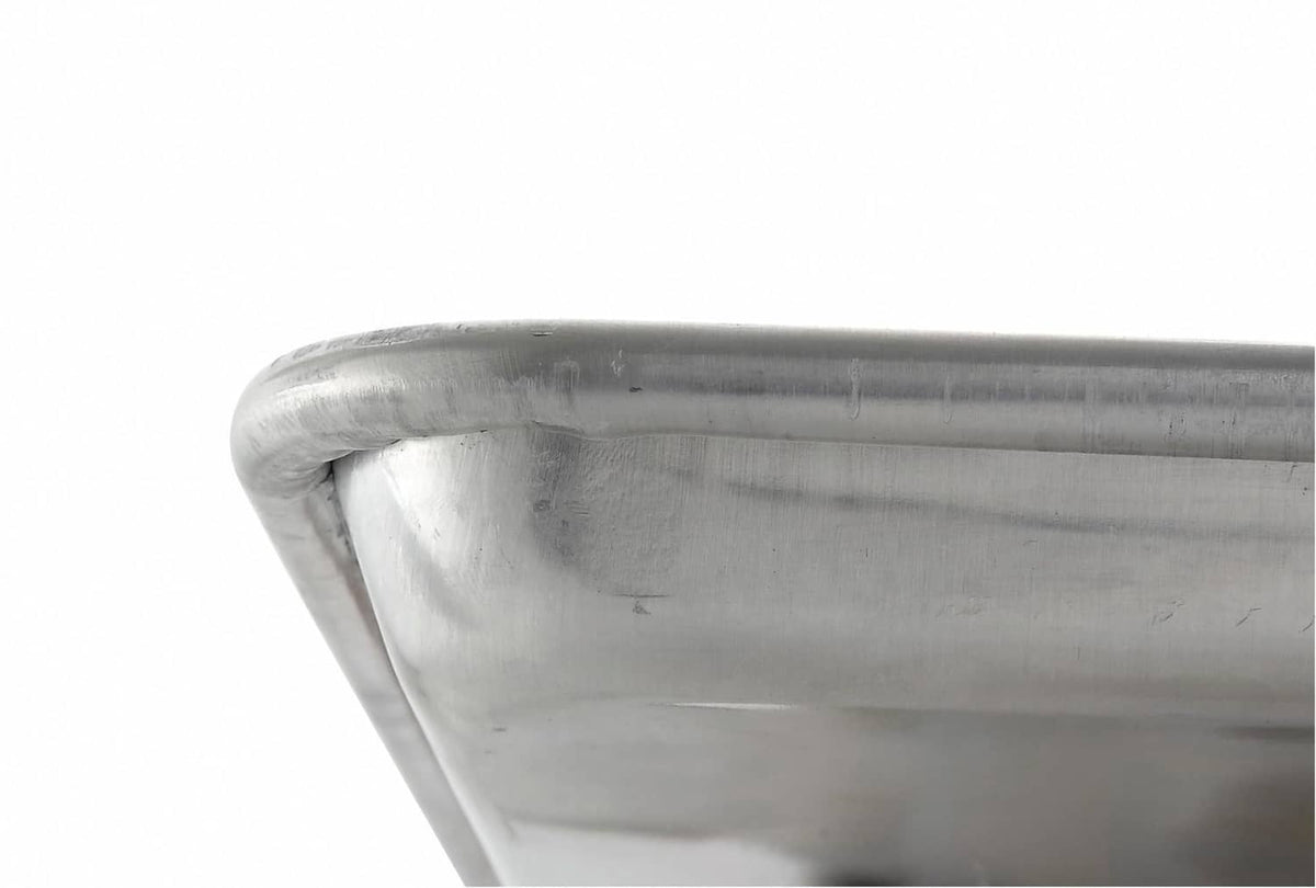Silver sheet pan corner with rolled rim and smooth interior