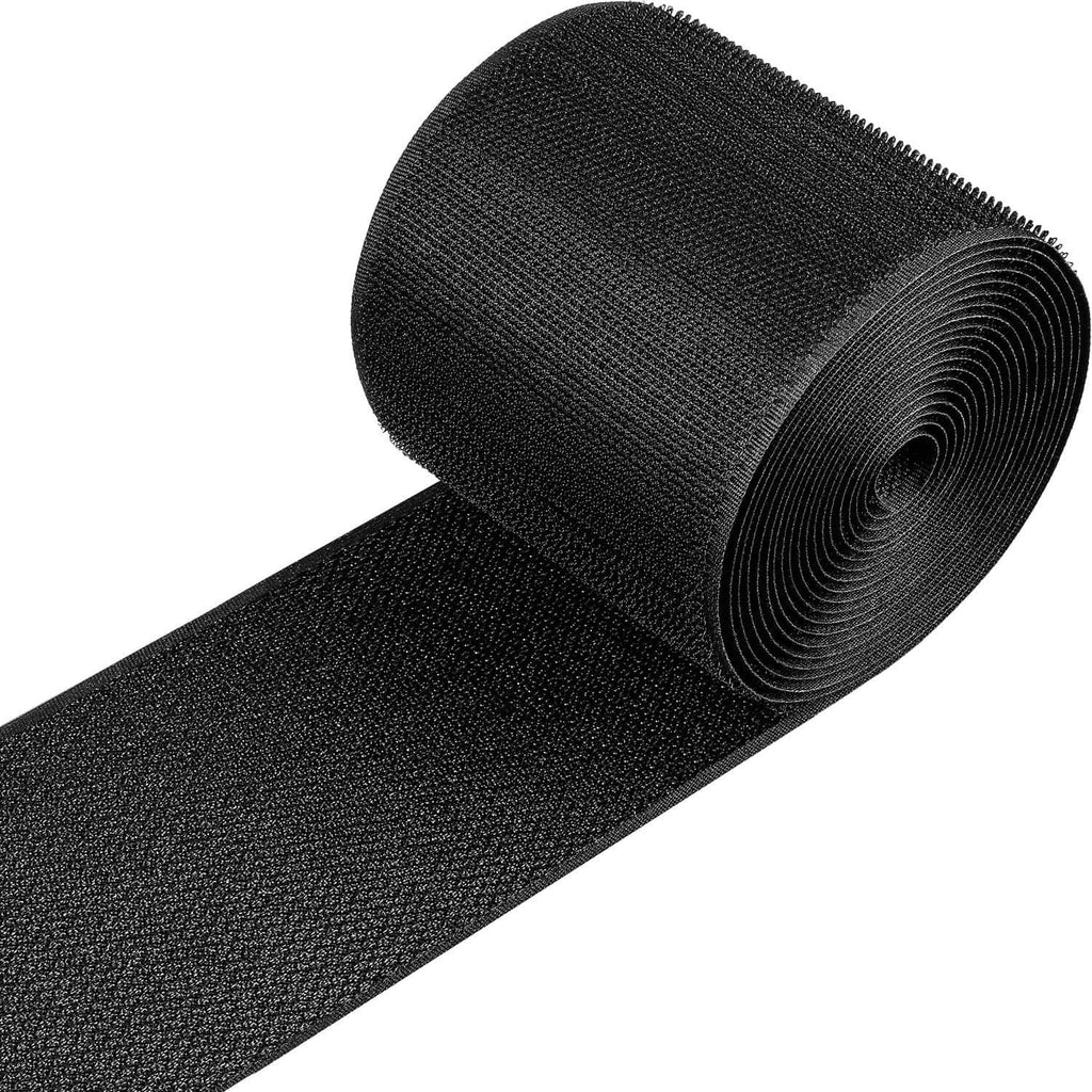 Black cable floor protection strip with textured grip surface, rolled for storage