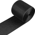 Black cable floor protection strip with textured grip surface, rolled for storage