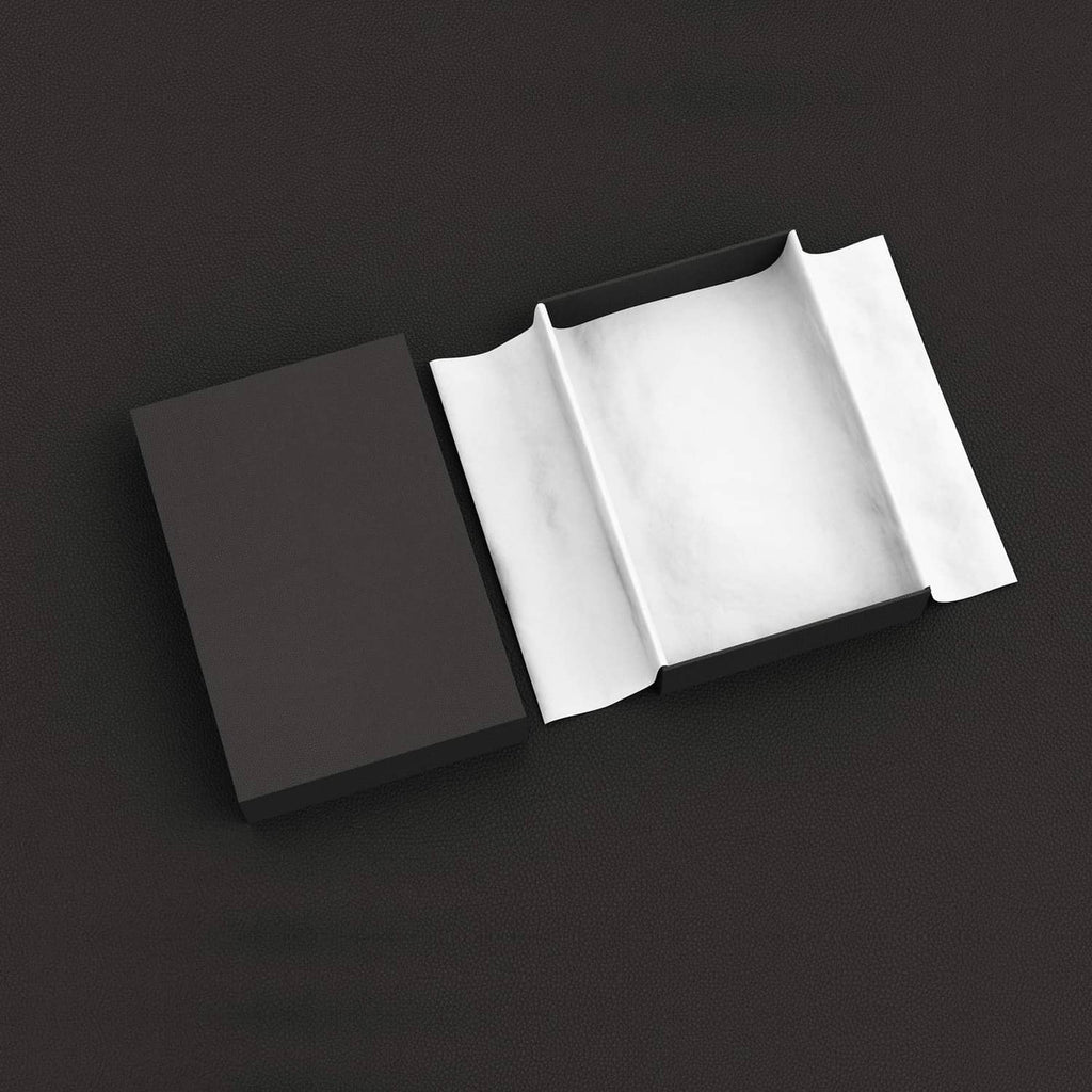 White tissue paper sheets folded around a wrapped gift for neat cushioning