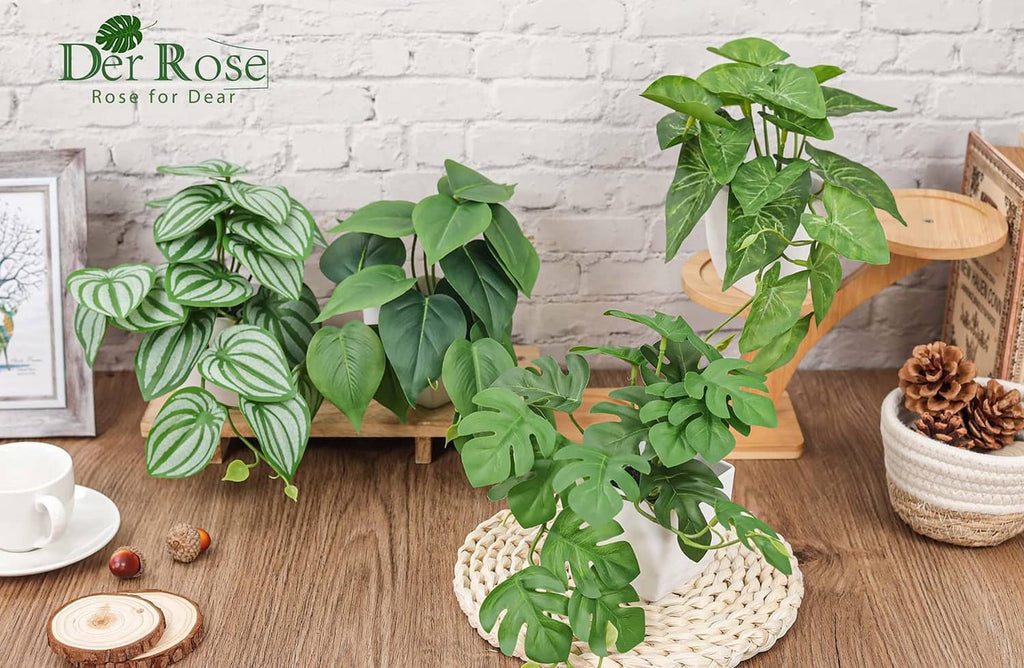 Green artificial vine plants with striped and solid leaves in white pots