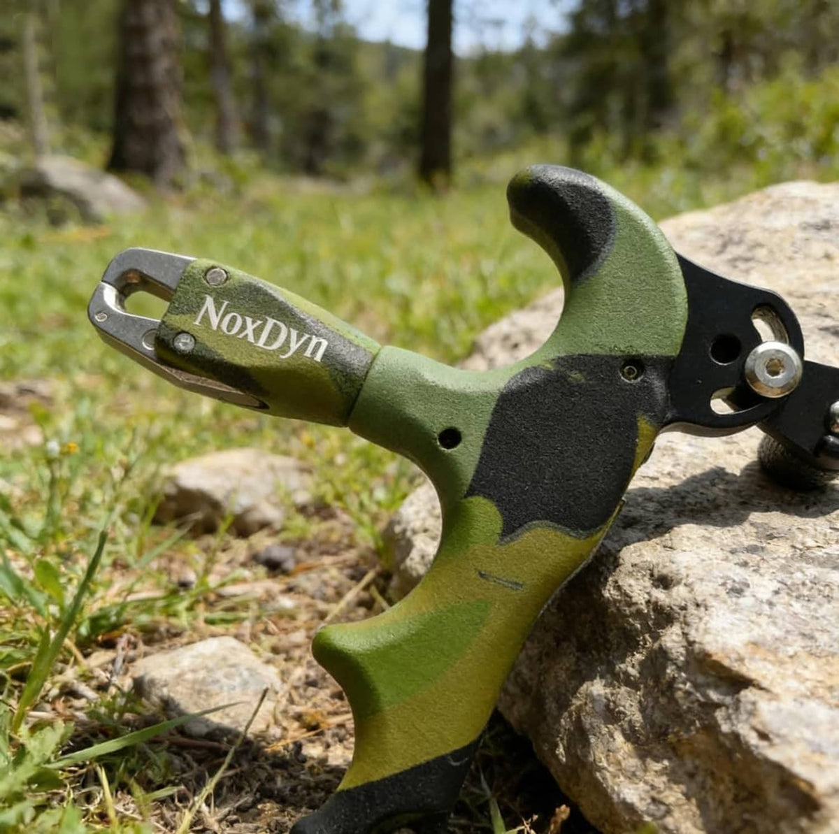 Archery thumb release, camo green/black grip, black trigger button, NoxDyn metal jaw