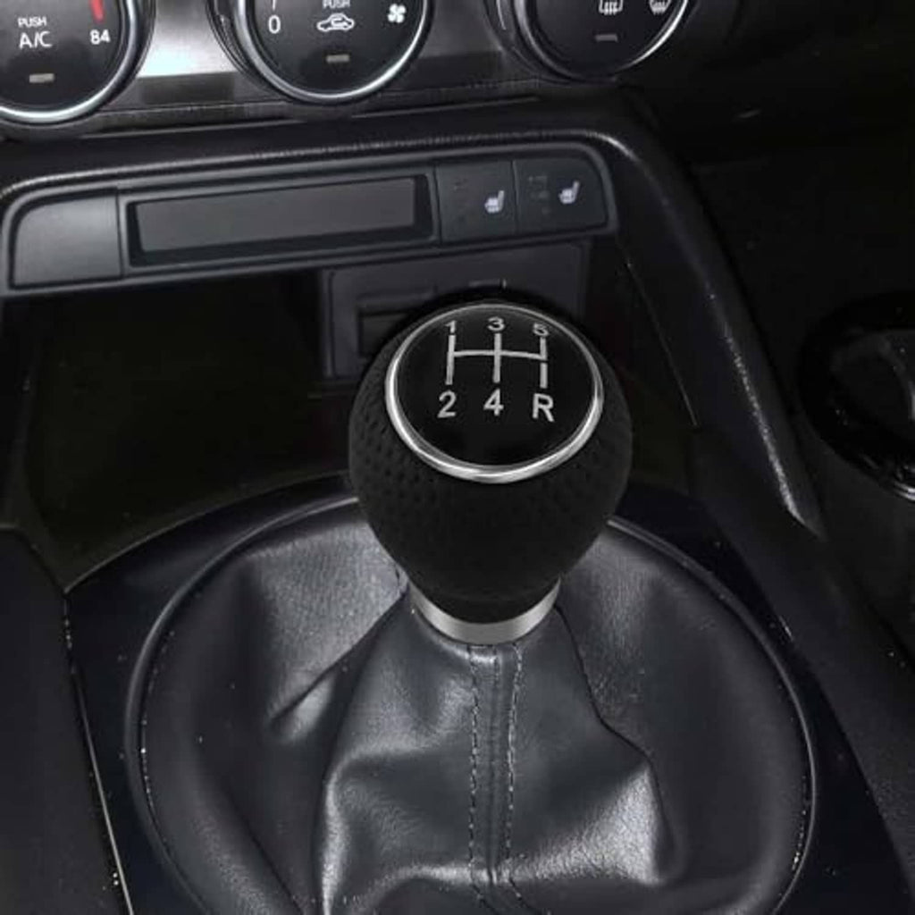 Black gear shift knob with silver ring on leather shift boot