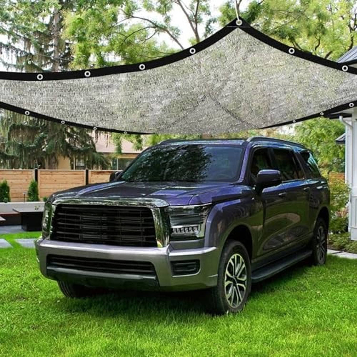 Gray aluminum shade cloth tarp suspended over a parked SUV, curved roof with grommets