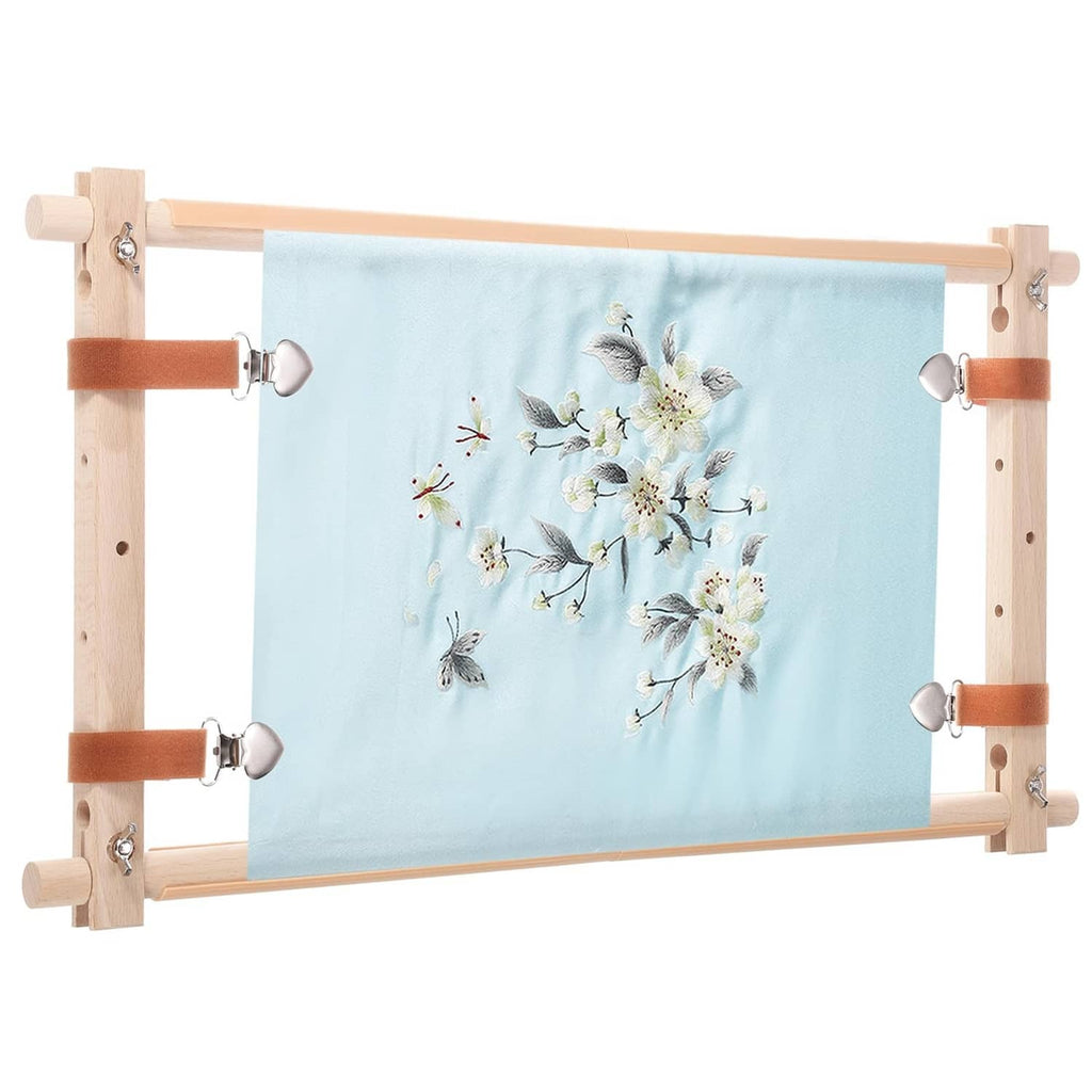 Wood needlepoint scroll frame holding light-blue floral embroidery fabric