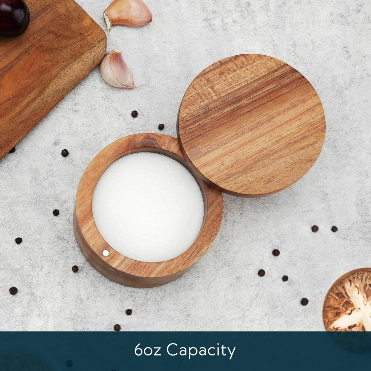 Acacia wood salt cellar bowl with round lid, filled with white salt