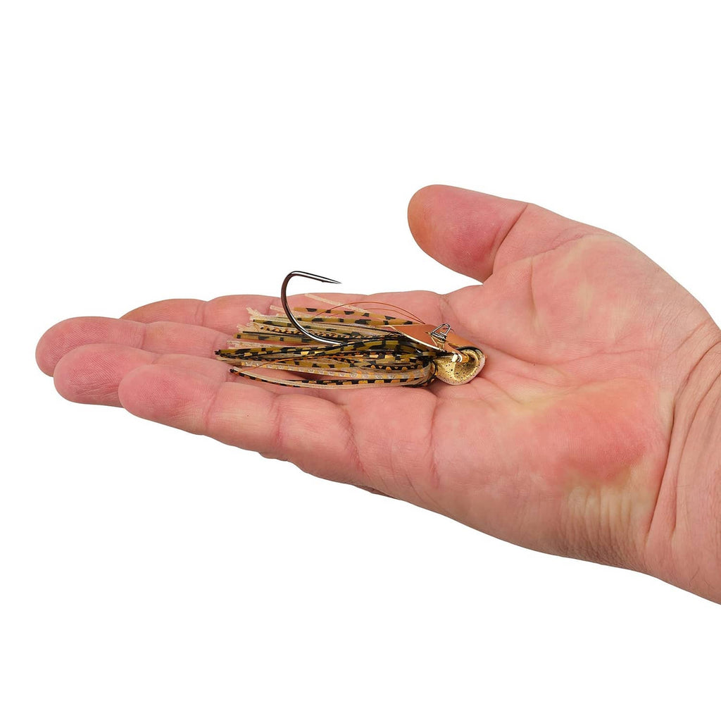 Bladed jig fishing lure in hand, tan and black skirt with gold hook and blade