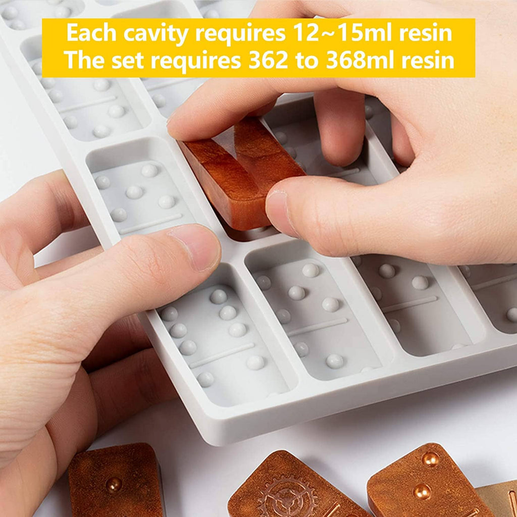 Hands placing a brown domino block into round-edged silicone mold cavities for resin casting