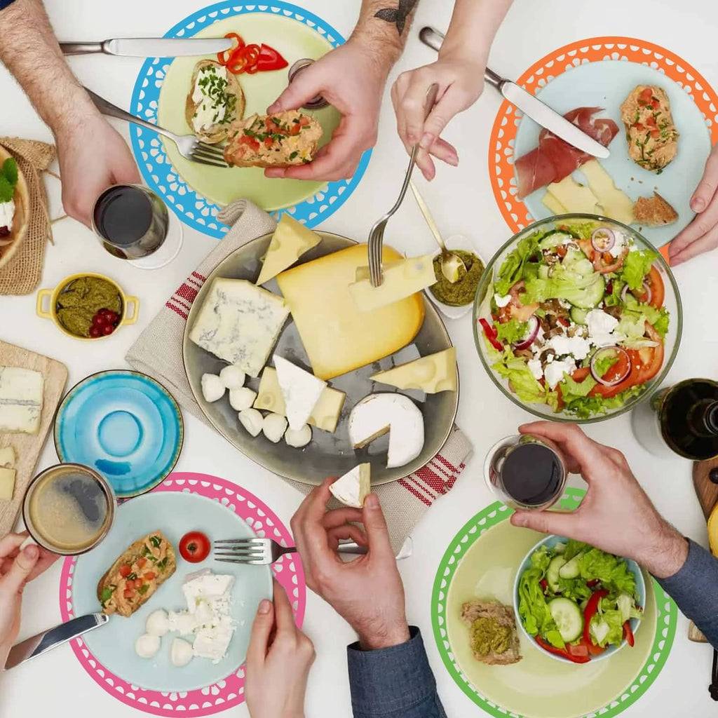 Assorted round Mexican paper place mats in blue, orange, green, and pink on a table