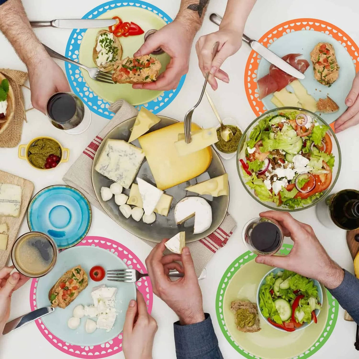 Assorted round Mexican paper place mats in blue, orange, green, and pink on a table