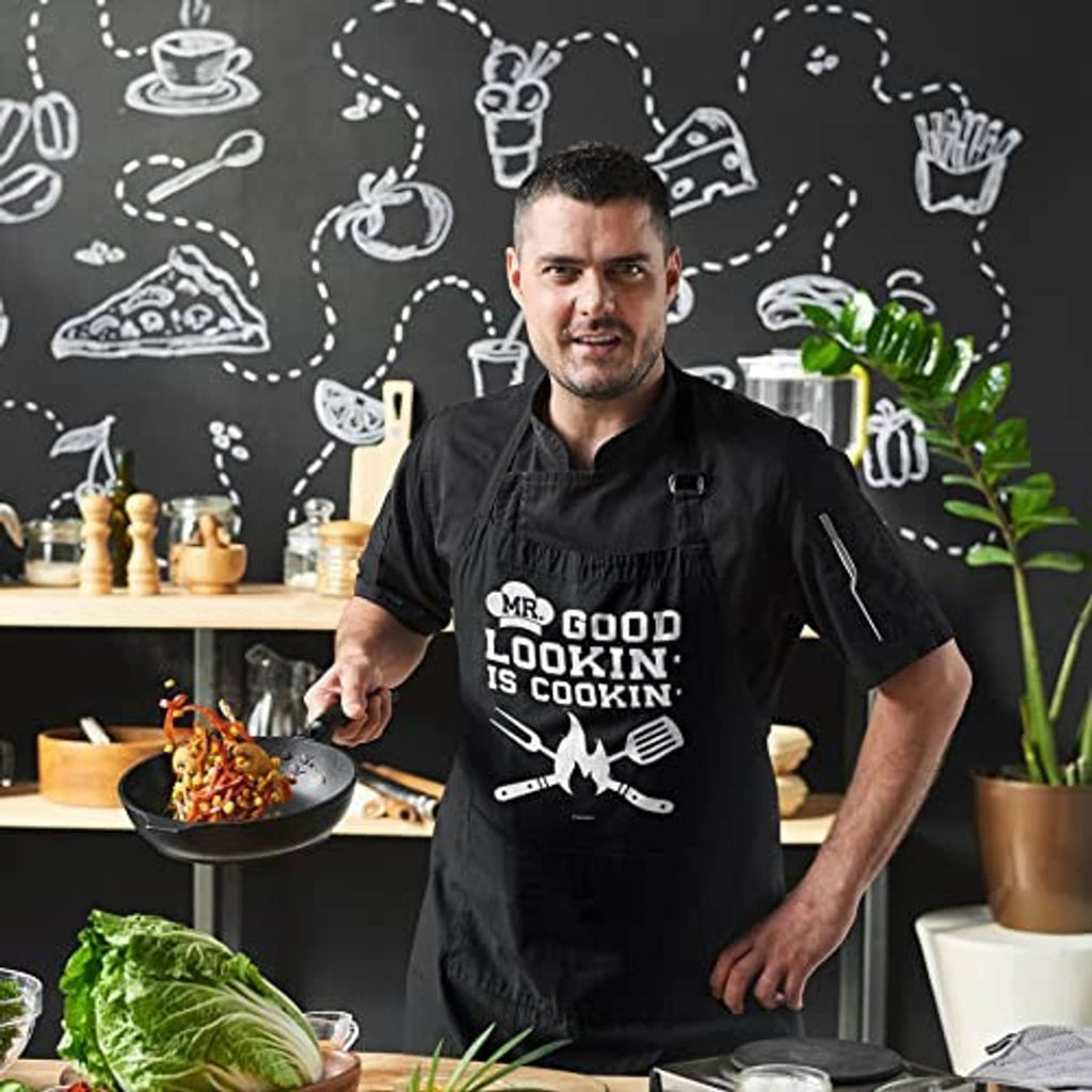 Black cotton apron with 'MR. GOOD LOOKIN' IS COOKIN' graphic, worn by cook