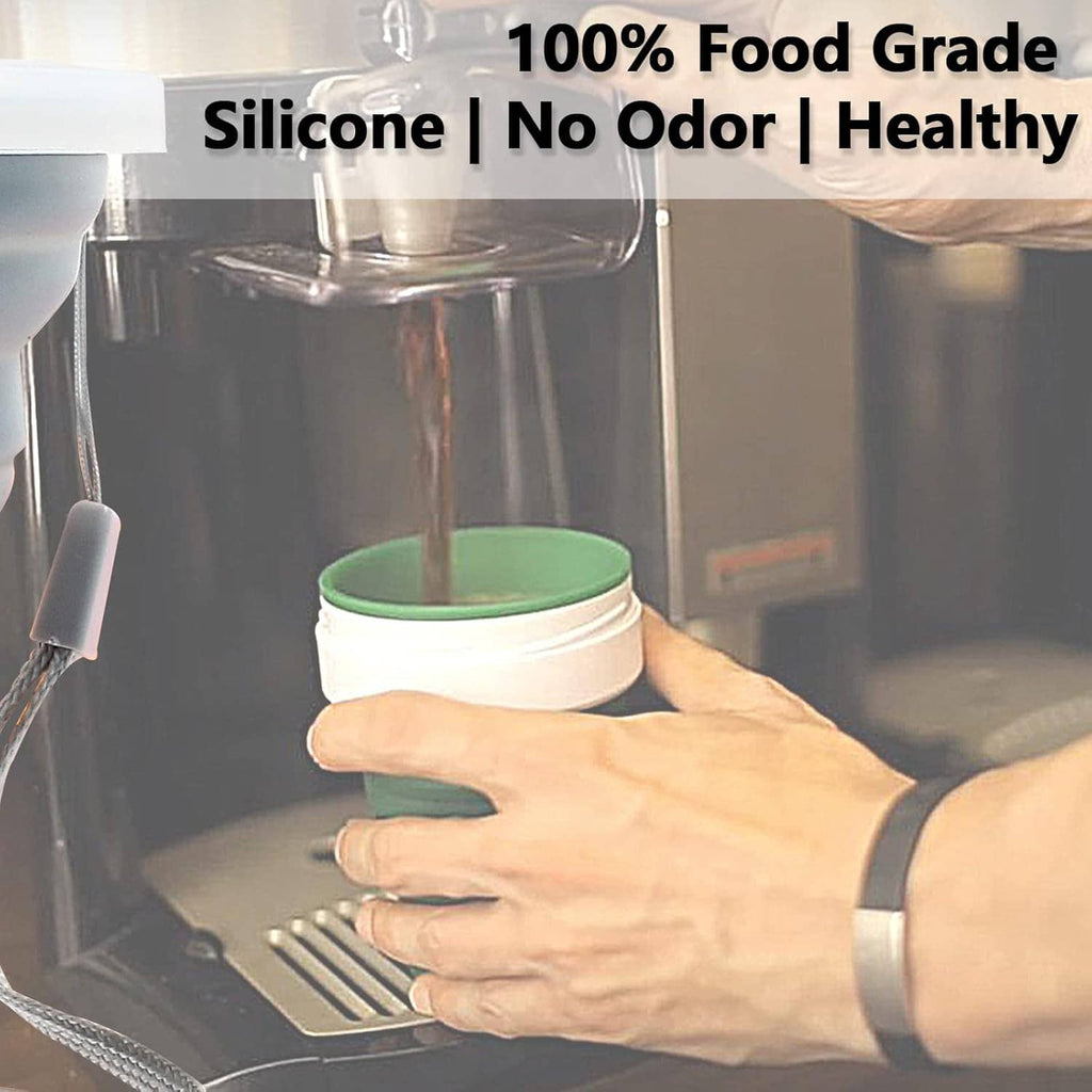 Collapsible silicone travel cup with green rim on hands near a metal sink