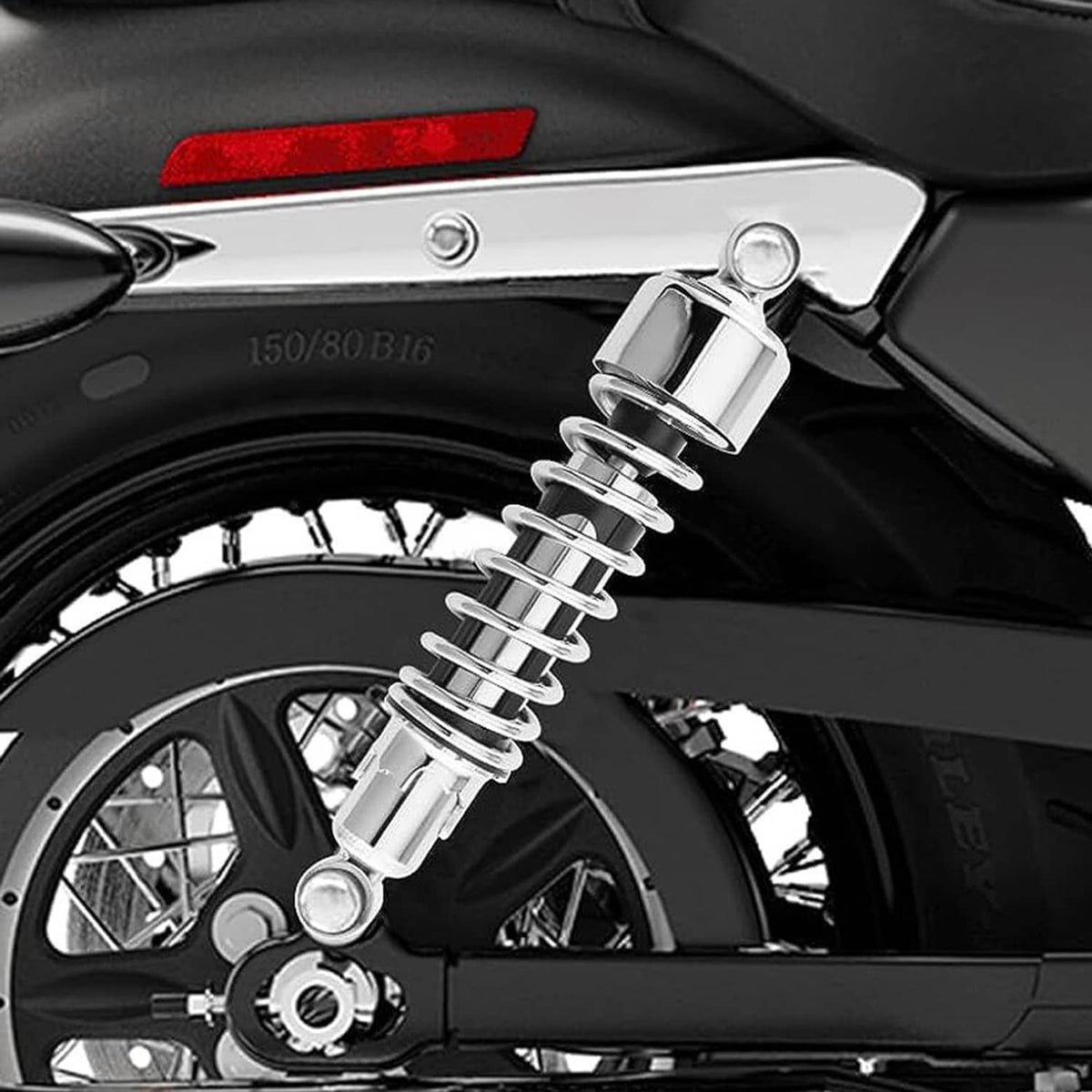 Chrome rear shock on a motorcycle with black coil spring and silver mount hardware