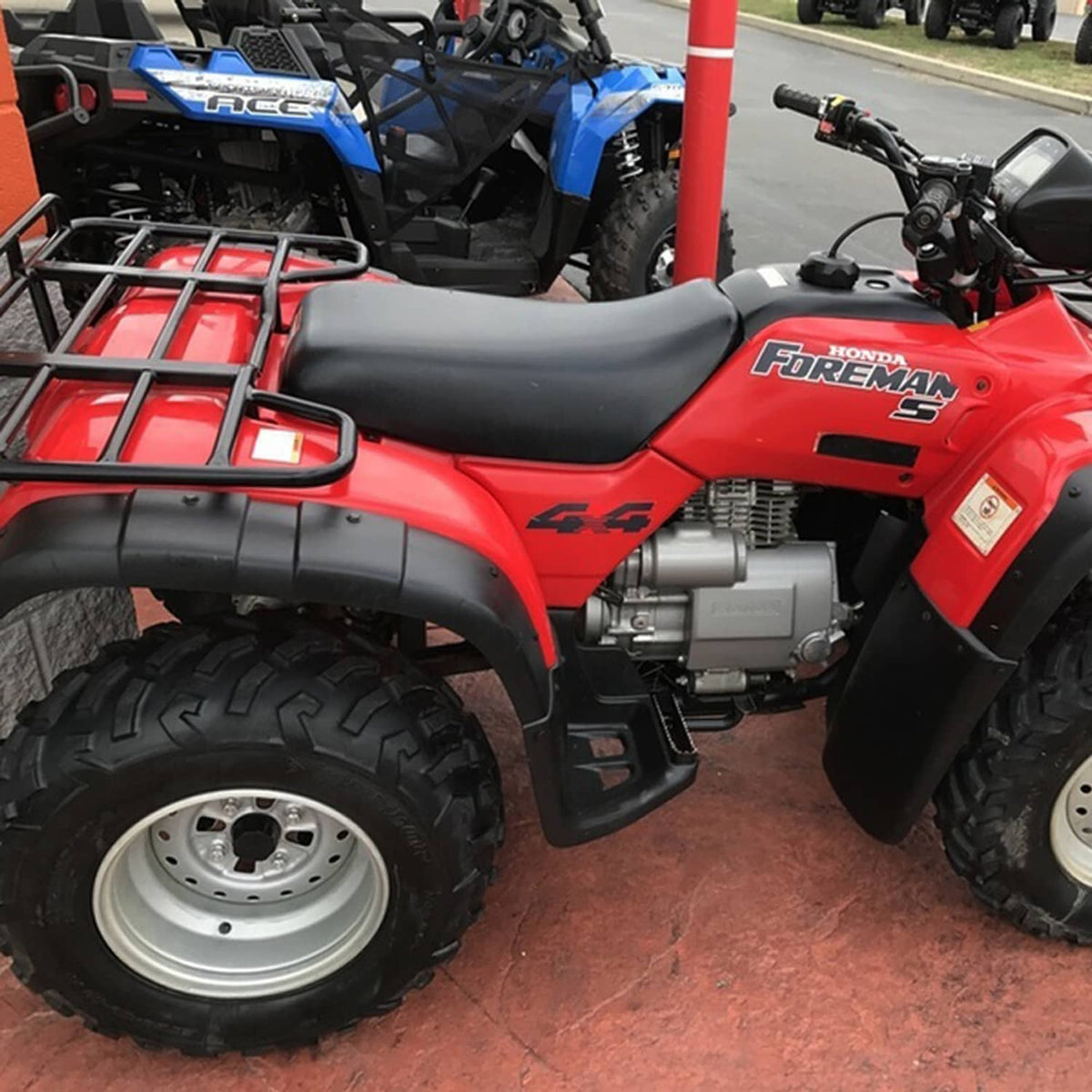 Black ATV seat with contoured padding mounted on a quad