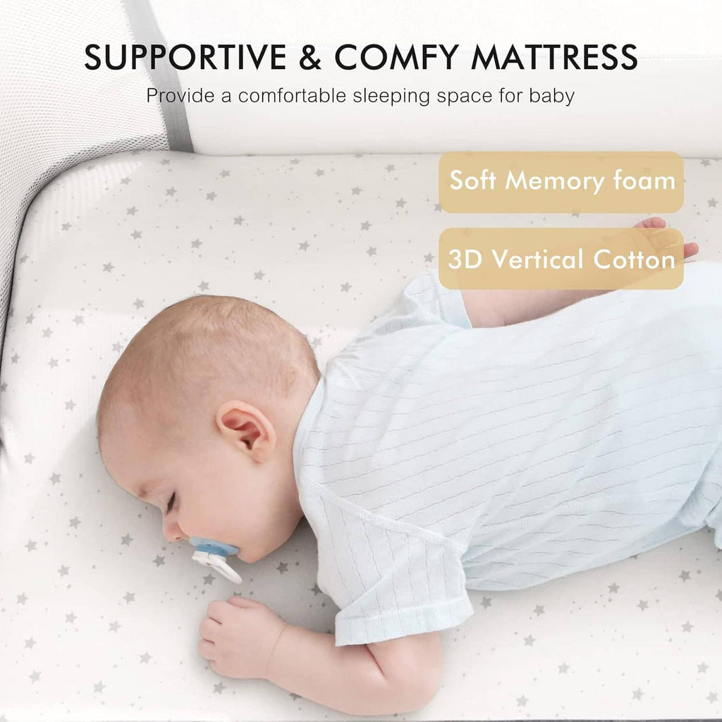 Baby bassinet mattress with soft padded surface, baby lying on white star-pattern mat.