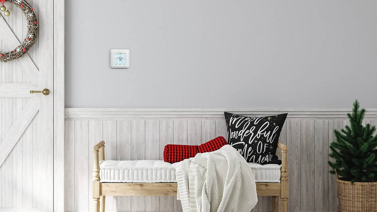 White wall-mounted Honeywell thermostat with small backlit touchscreen display