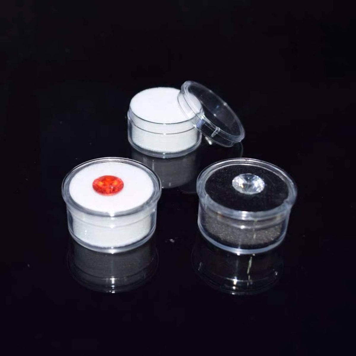 Round display boxes with red and clear gemstone stones, open-lid set of three