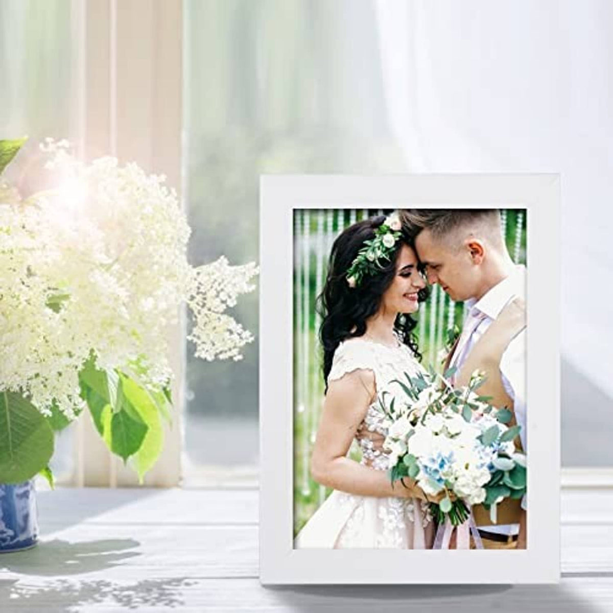 White 5x7 picture frame with clear front holding a couple wedding photo