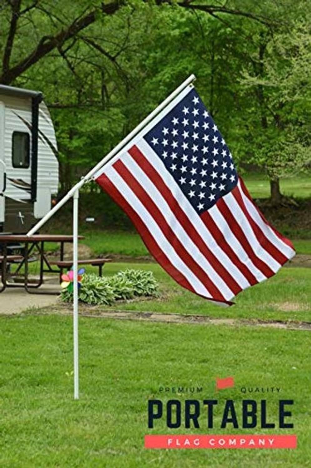 Portable flagpole with waving U.S. flag on vertical white pole
