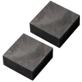 Graphite ingot blocks, dark gray rectangular prisms arranged side by side