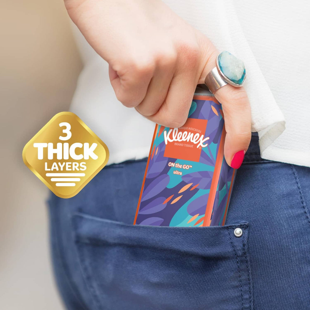 Hand holding Kleenex On-the-go pocket tissue pack with 3 thick layers