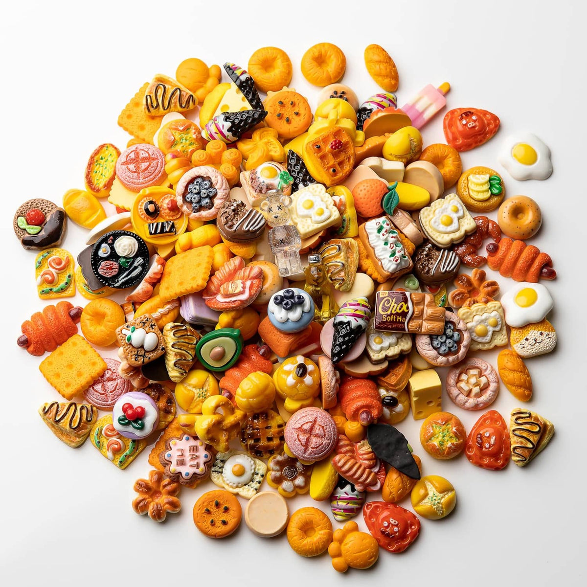 Large pile of assorted resin food charms: mini pastries, donuts, pizza, berries, and candy