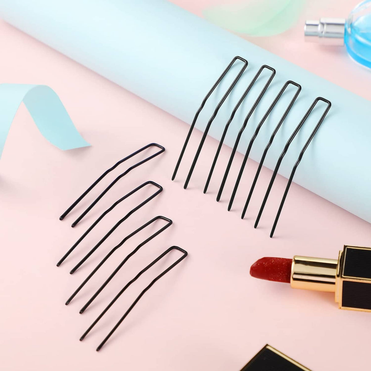 Black U-shaped hairpins, several pins laid out on pastel background