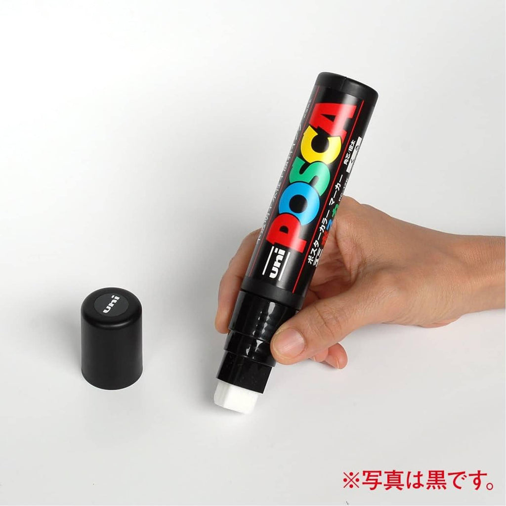 White extra bold paint marker with cap, held in hand; Uni Posca PC17K.1.