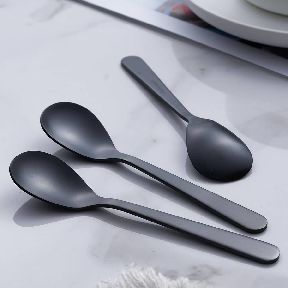 Matte black espresso spoons, satin finish, angled view of bowls and handles