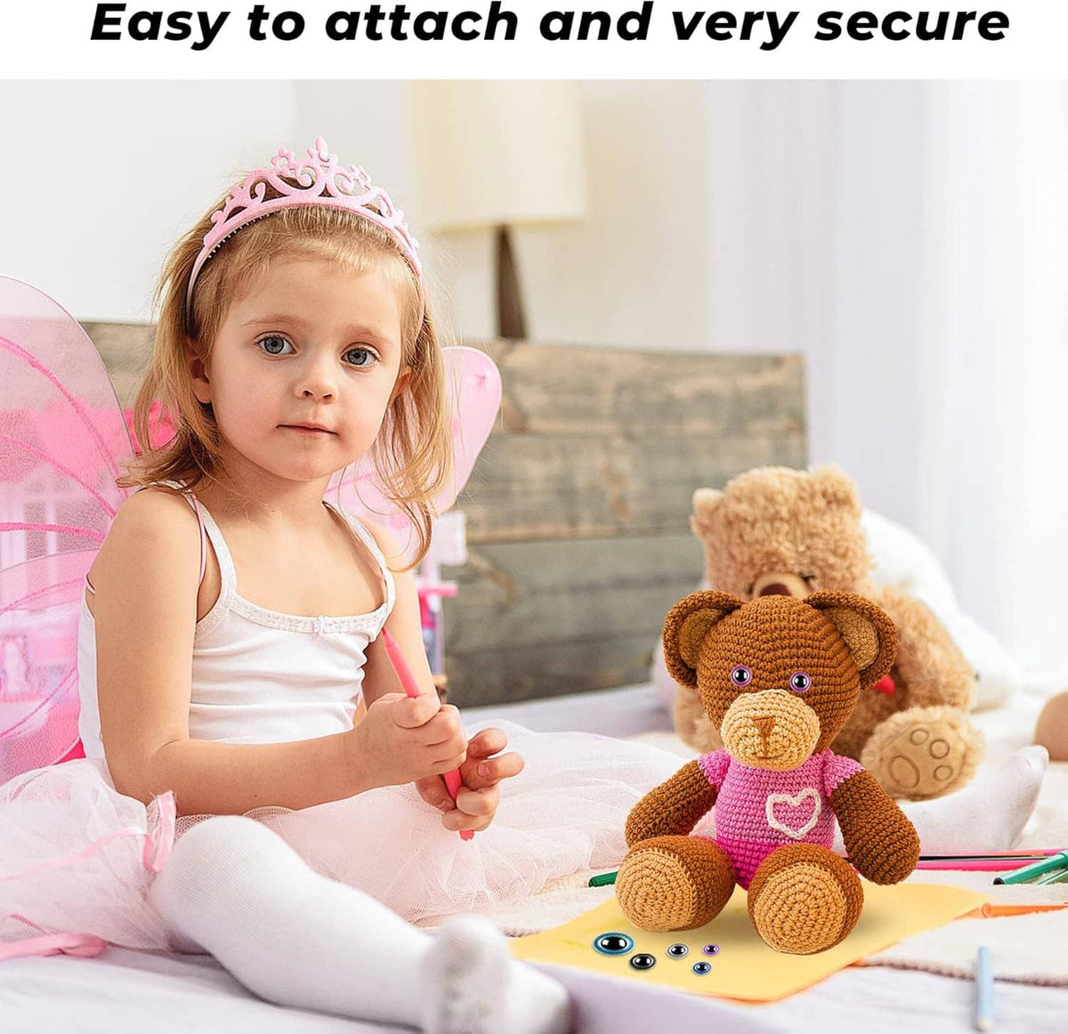 Kid holding a plush teddy with safety eyes while playing on a table