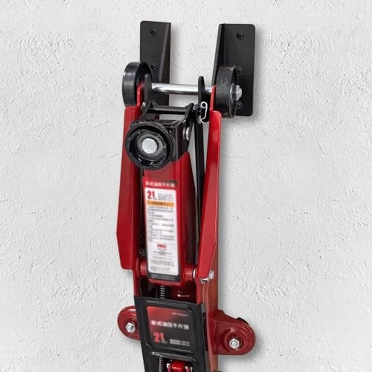 Wall-mounted jack stand bracket with red hydraulic trolley jack close-up