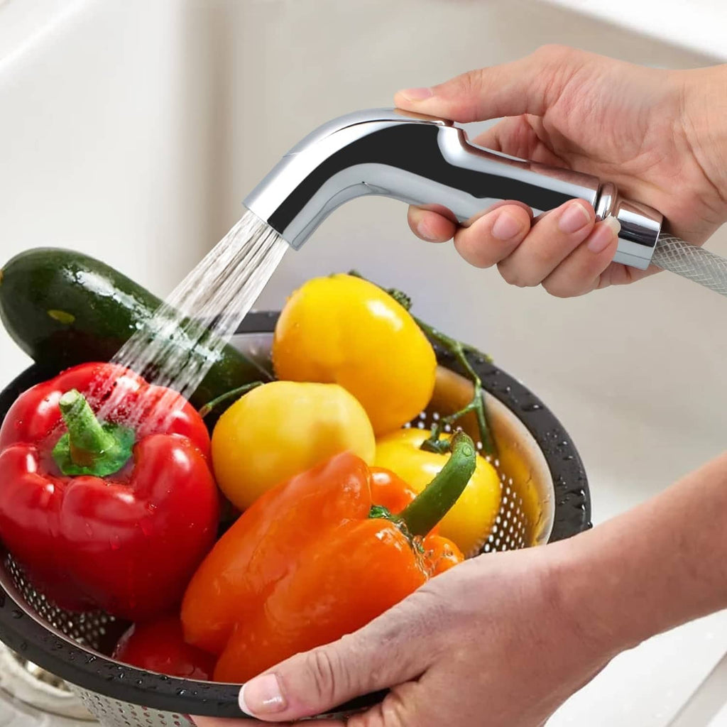 Chrome sink sprayer spraying water onto vegetables in a basin
