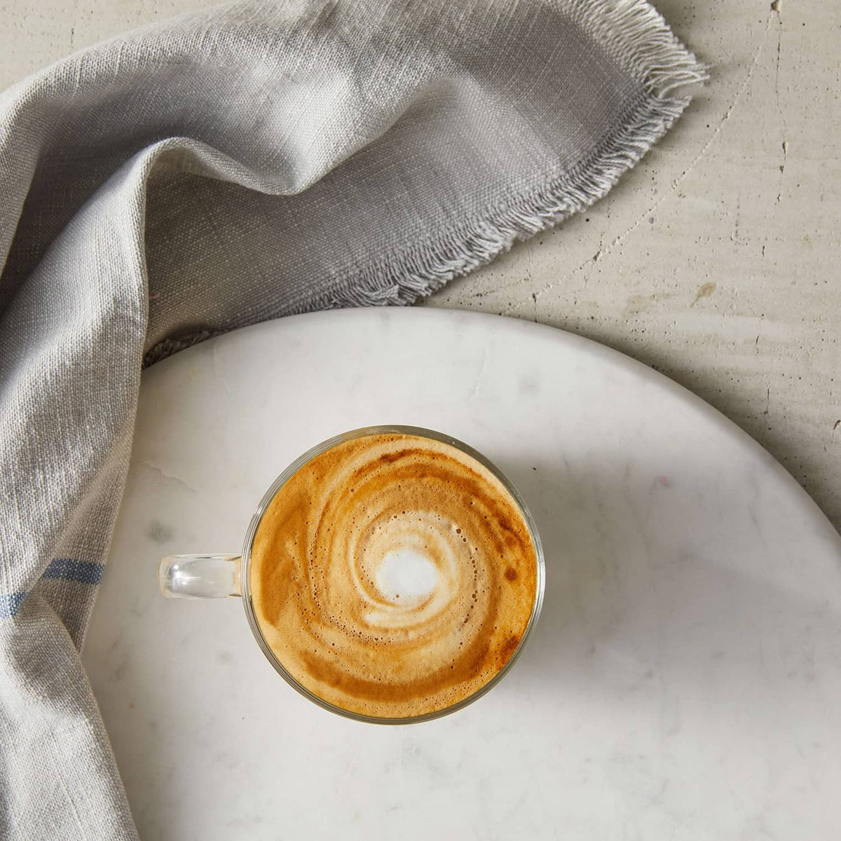 Cup of vanilla syrup latte with creamy foam and latte-art swirl