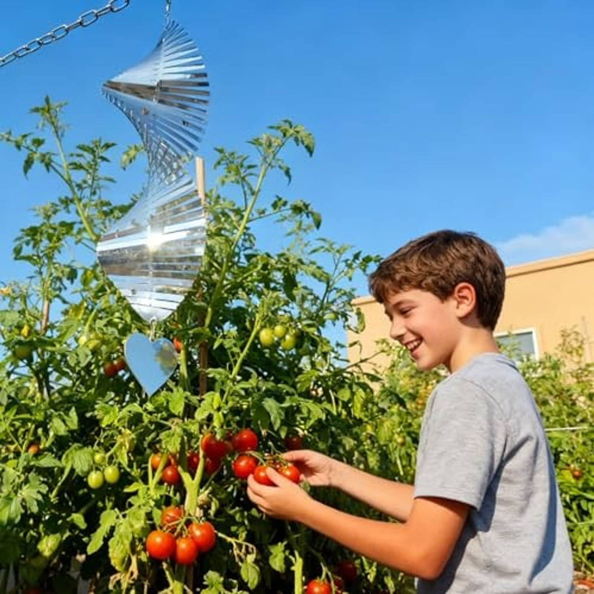 Reflective bird-deterrent wind spinner with heart charm hanging outdoors