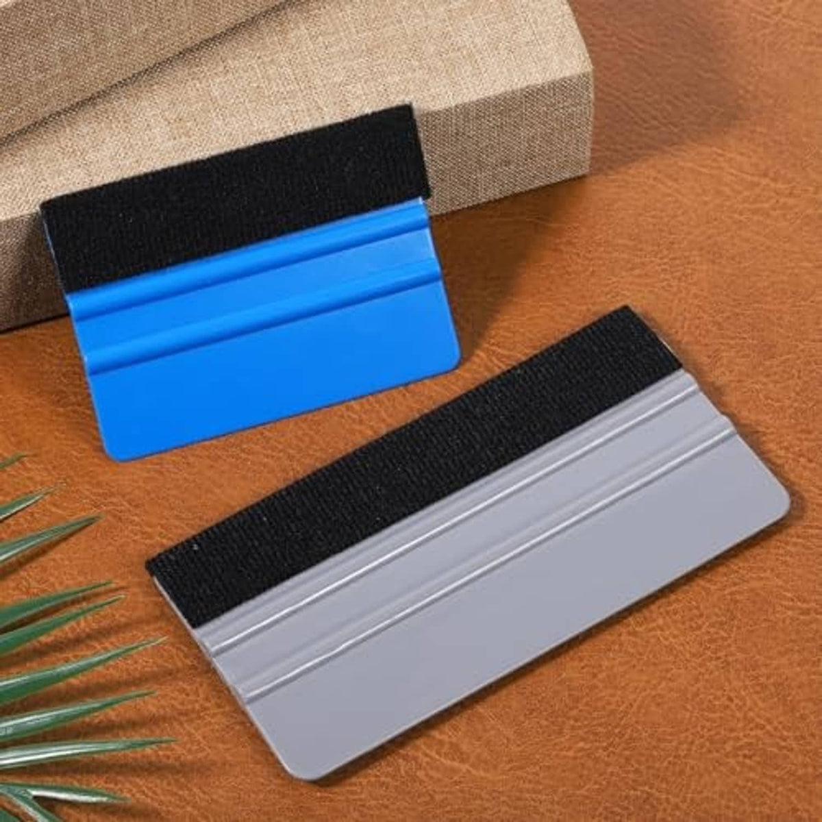 Two felt squeegees laid out: blue pad and gray pad with handle bases