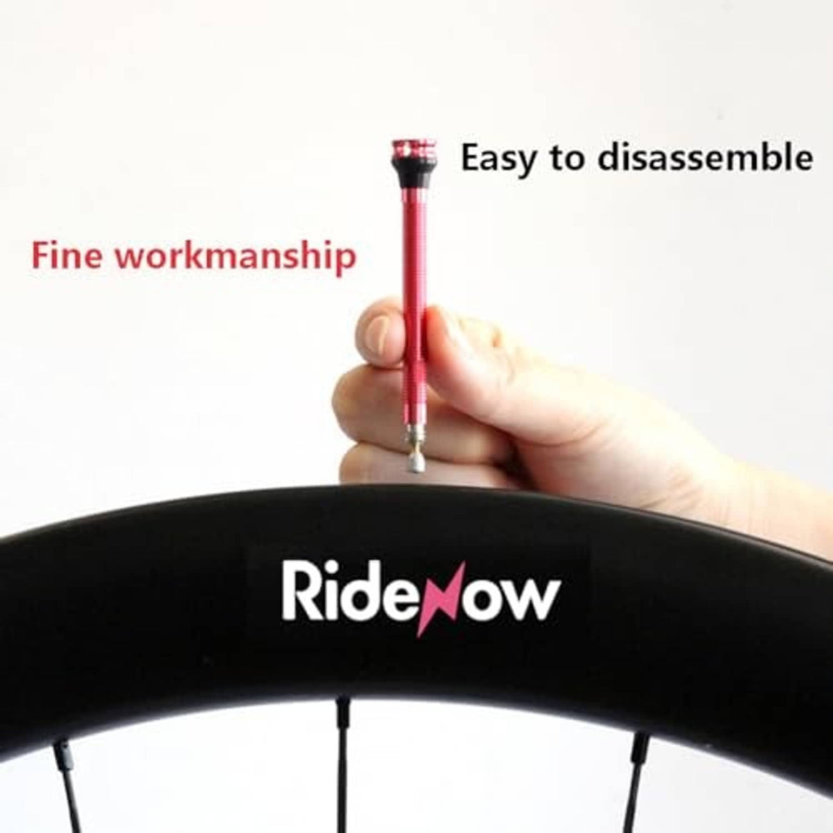 Red Presta valve stem being installed through a bike tire opening