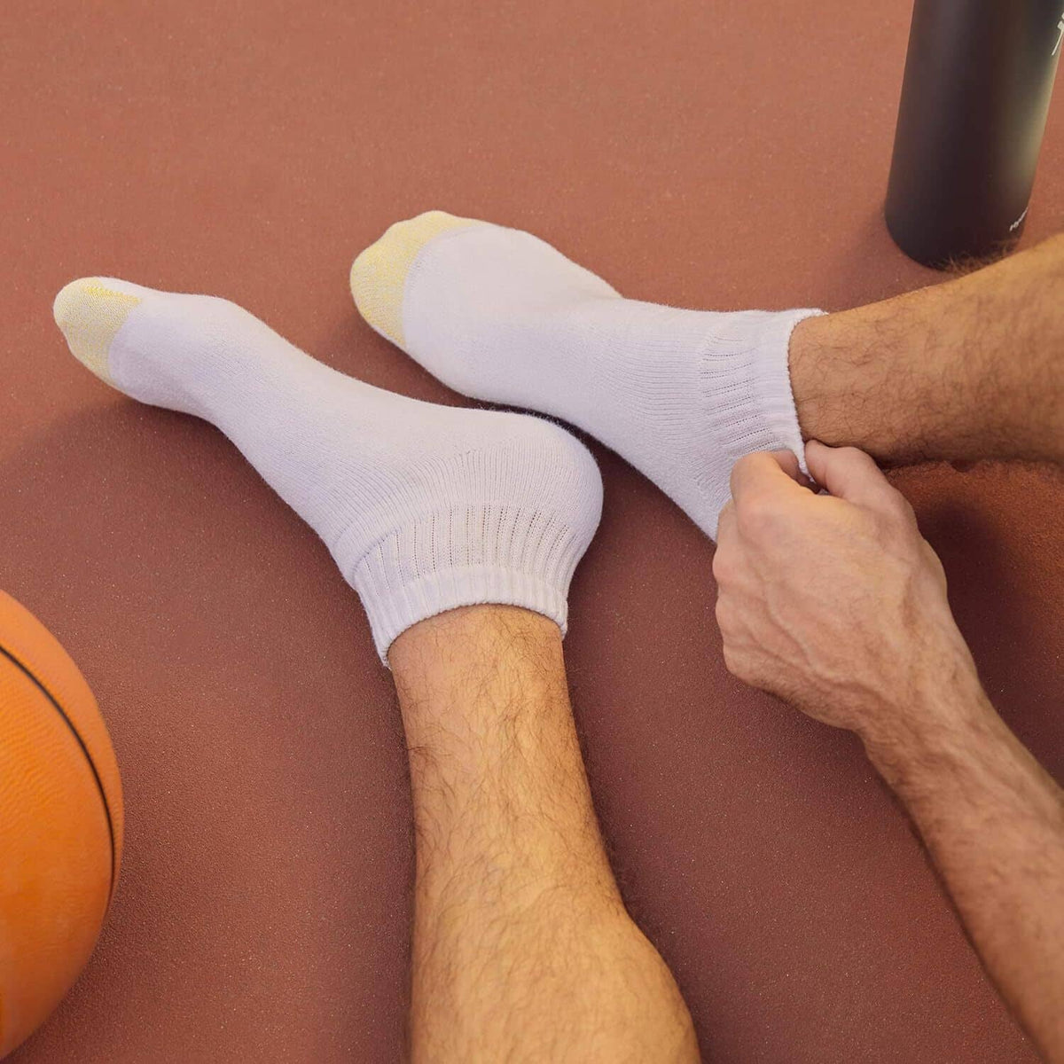 White athletic crew socks on model's feet, cuffed length