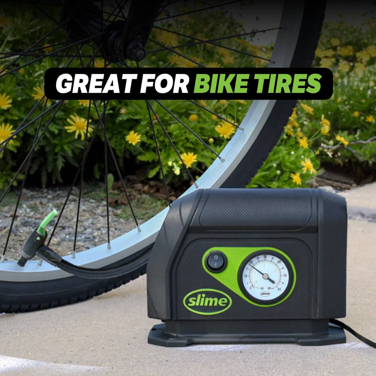 Portable tire inflator with analog gauge and air hose, placed near a bike wheel