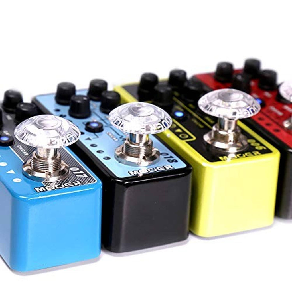 Clear mushroom-shaped guitar pedal footswitch toppers on blue, black, and yellow pedals