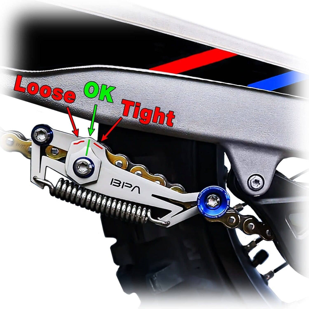 Motorcycle chain slack adjuster tool head showing bolt and blue dial