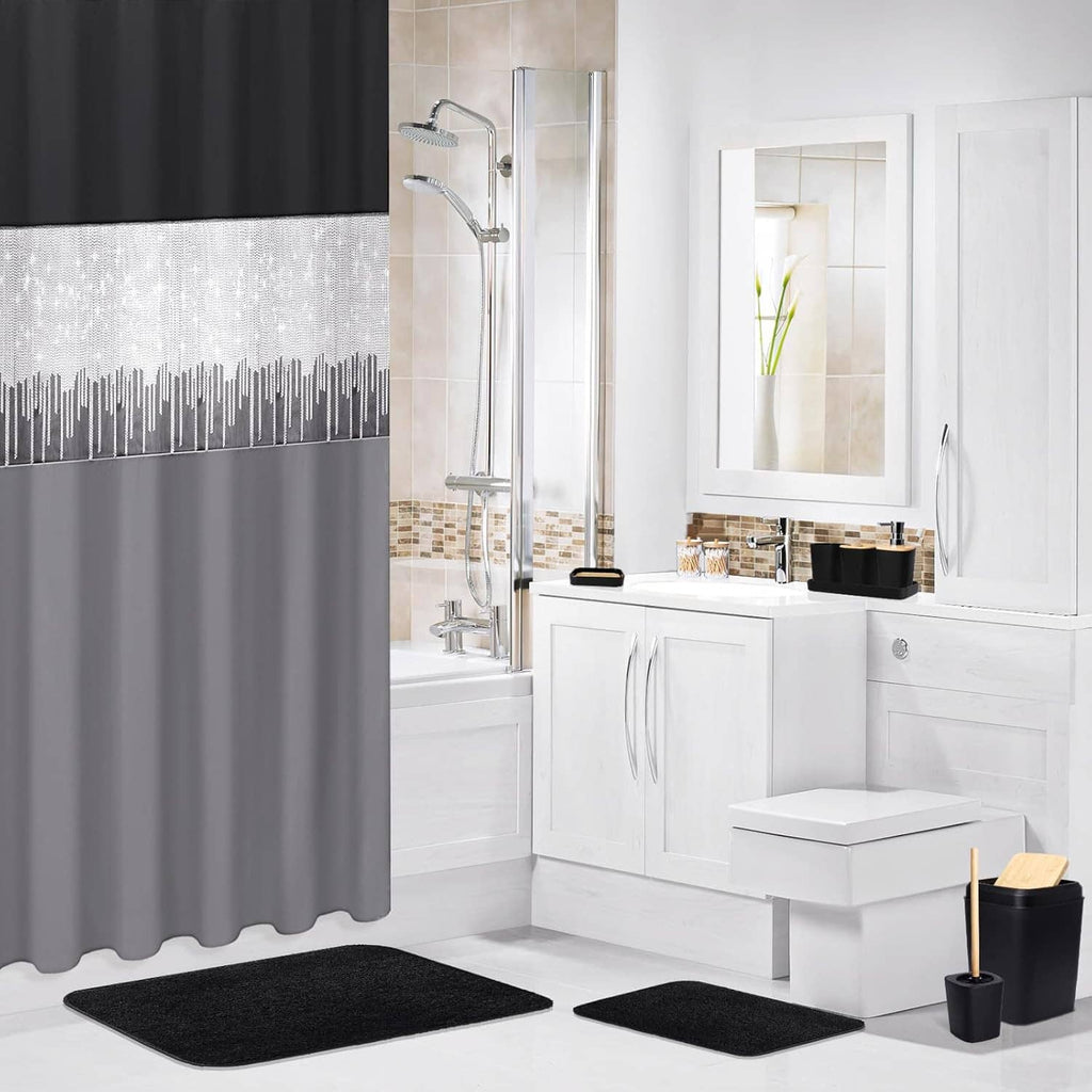 Black and gray shower curtain with two black bathroom rugs in a white bathroom