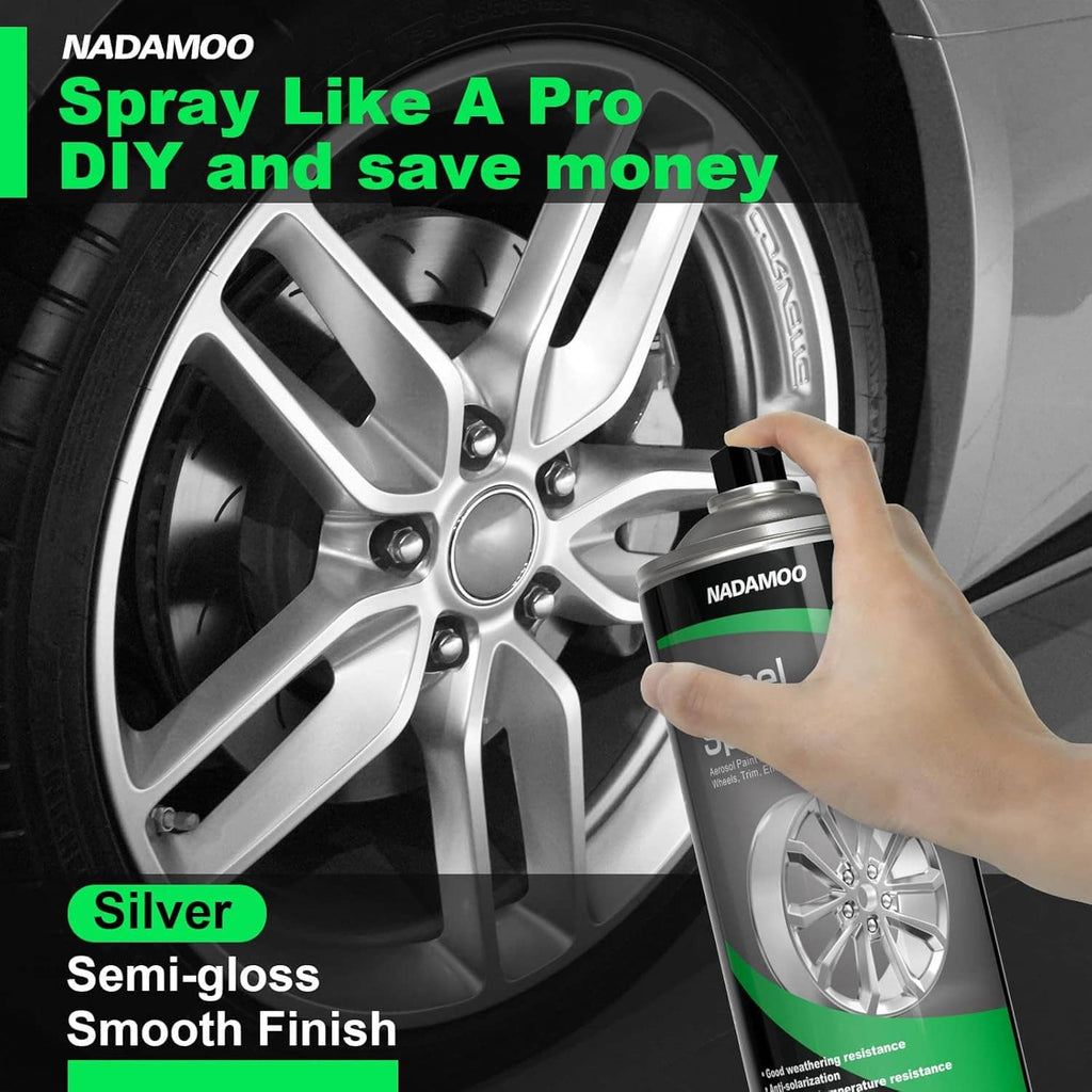 Hand holding wheel spray paint aerosol over silver alloy car rim, semi-gloss finish