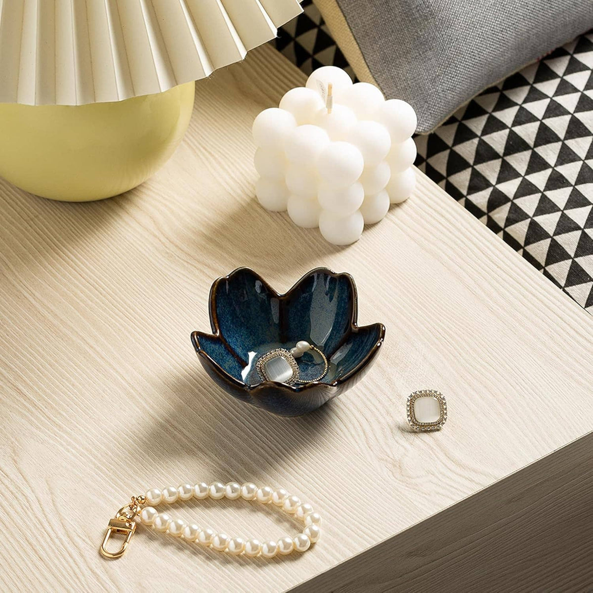 Ceramic flower ring holder dish in dark blue with small rings and pearl tray accents