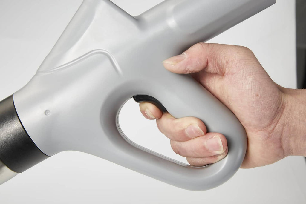 Gray toilet air plunger handle with black nozzle end, hand gripping trigger area