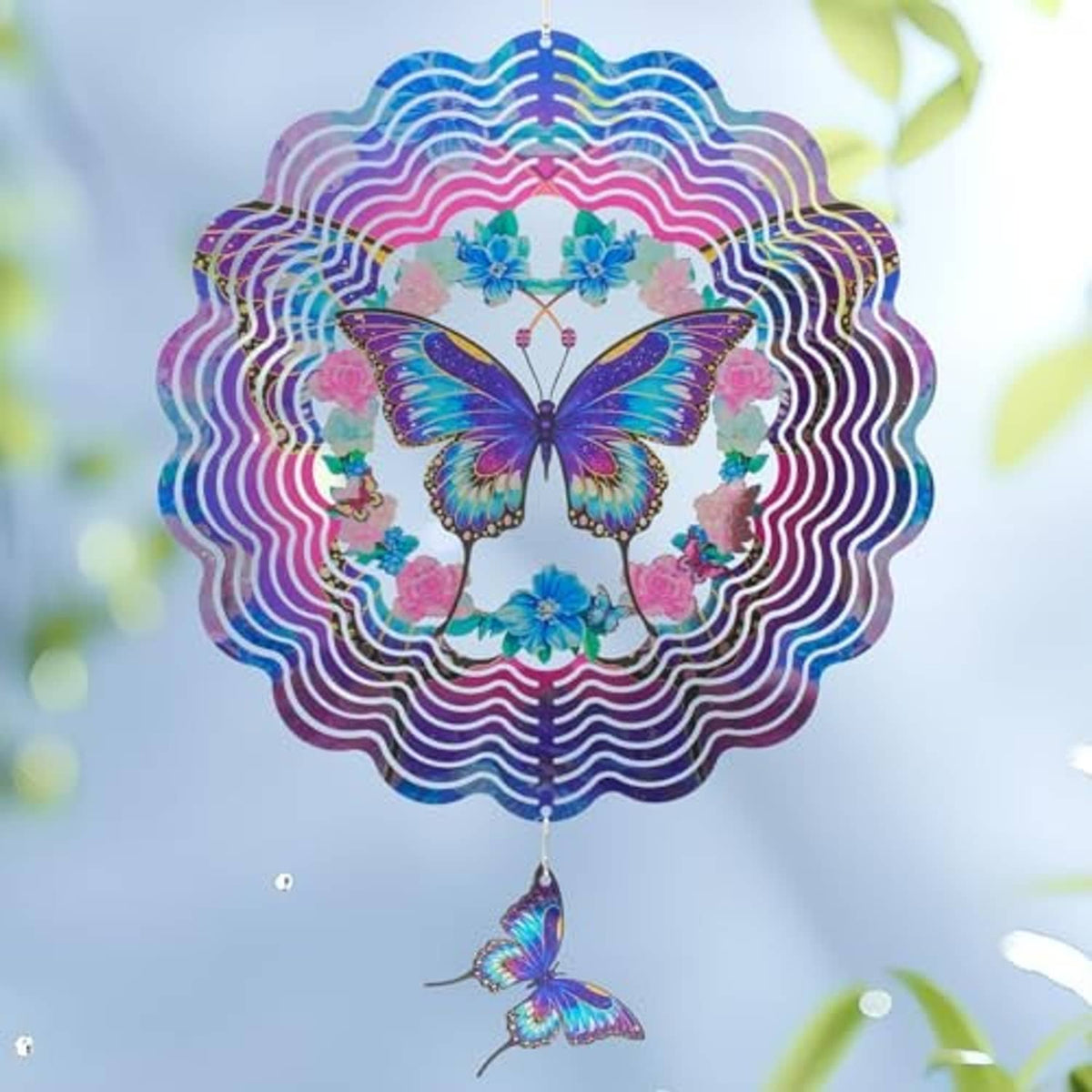 Front view hanging butterfly wind spinner with blue butterfly, pink floral accents, spiral ring edges
